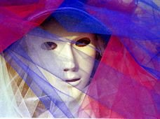 Un masque blanc enveloppé de voiles bleus, roses et violets.